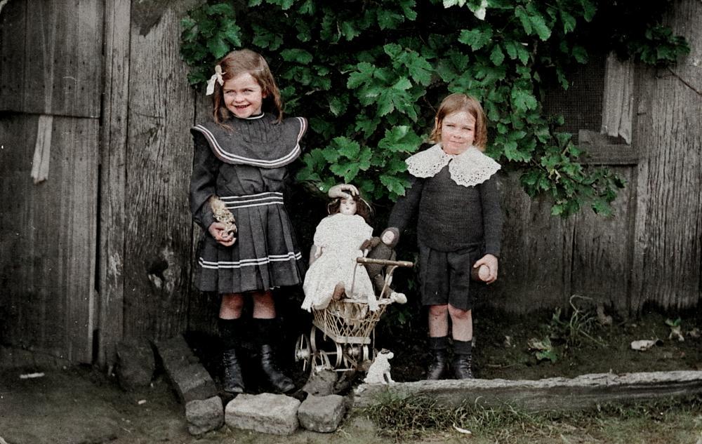 Mary and Patrick Tracey with their dolls and a toy pram, Cecil Plains, Queensland, 1900s, in colour